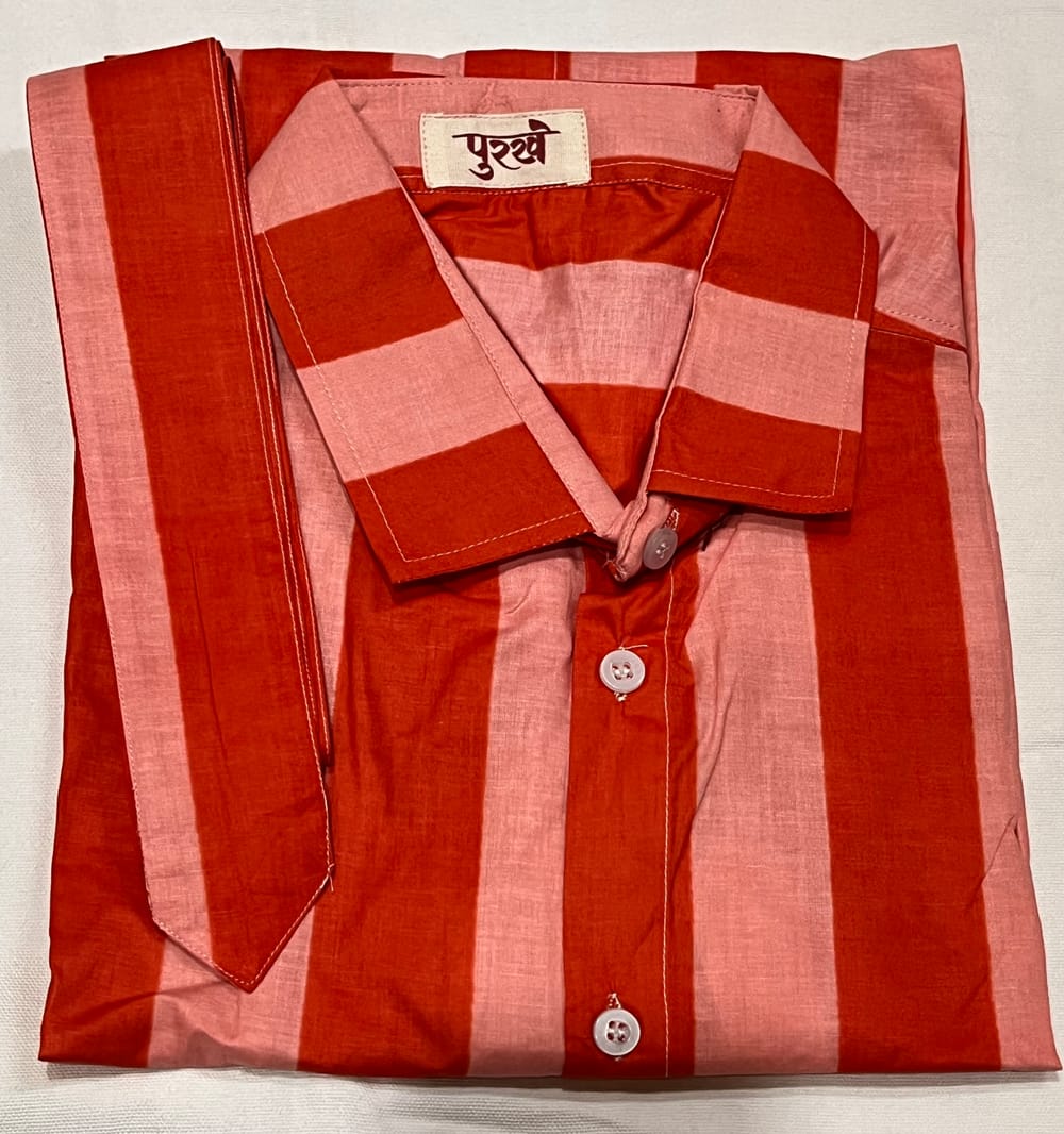 The Striped Shirt in Peach, folded, with the Purkhe label